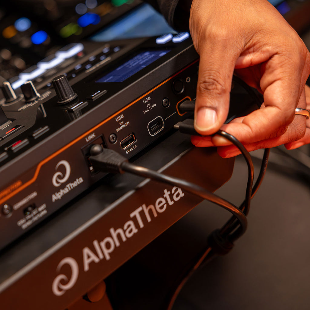 AlphaTheta RMX-IGNITE DJ effects unit connected to a digital send and return setup, showcasing controls and digital interface.