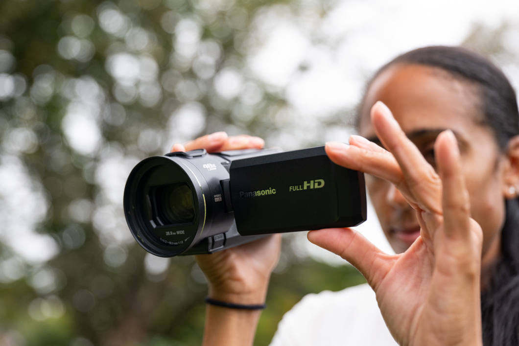 Panasonic HC-V900 camcorder with 1060W lens, showing its compact design and lens details for high-quality video recording.