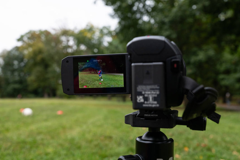 Panasonic HC-V900 camcorder with 1060W lens, showing its compact design and control buttons for high-quality video recording.