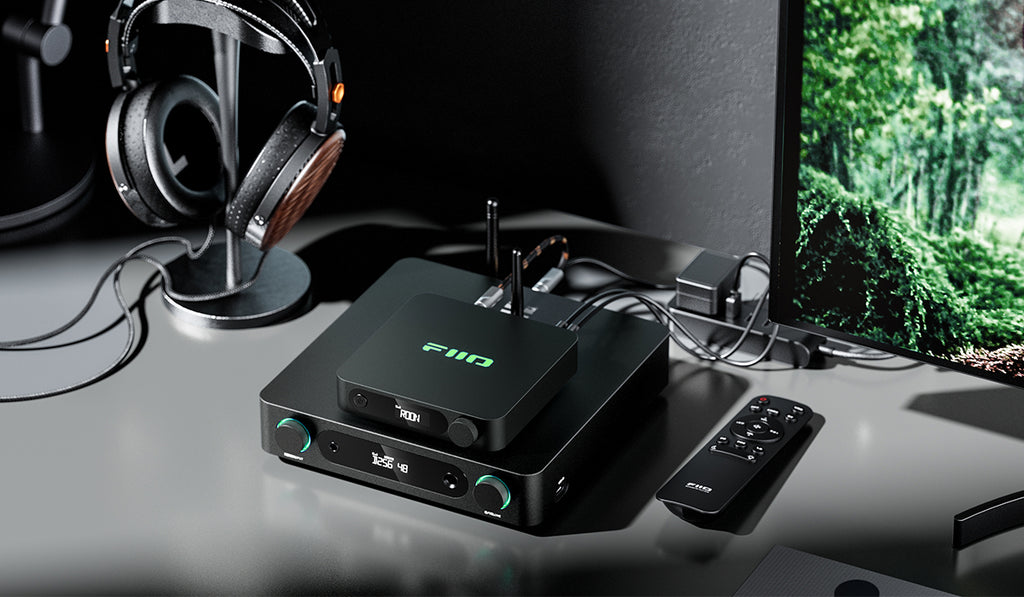 FiiO K13 R2R headphone amplifier and DAC showing front panel with multiple input and output ports and a sleek design.