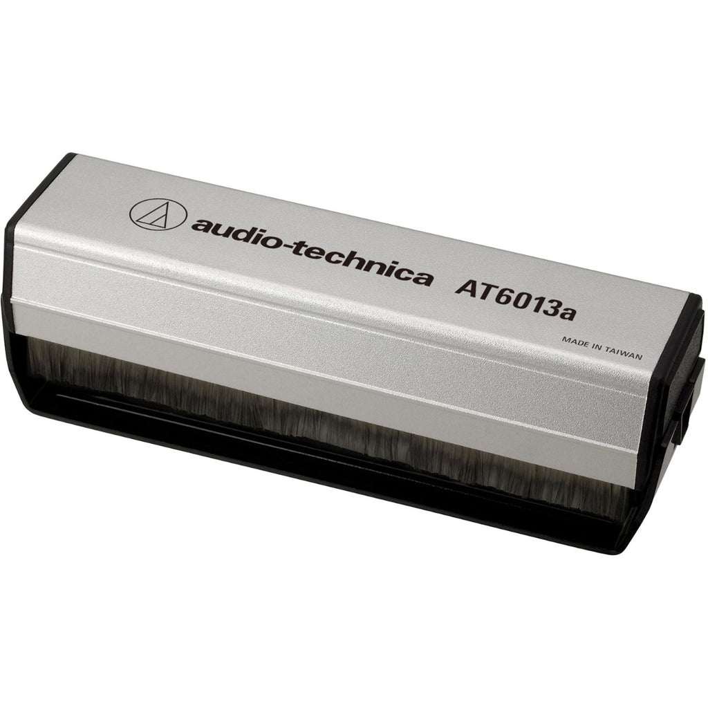 Audio Technica dual-action anti-static record brush cleaning a vinyl record to remove dust and static buildup.
