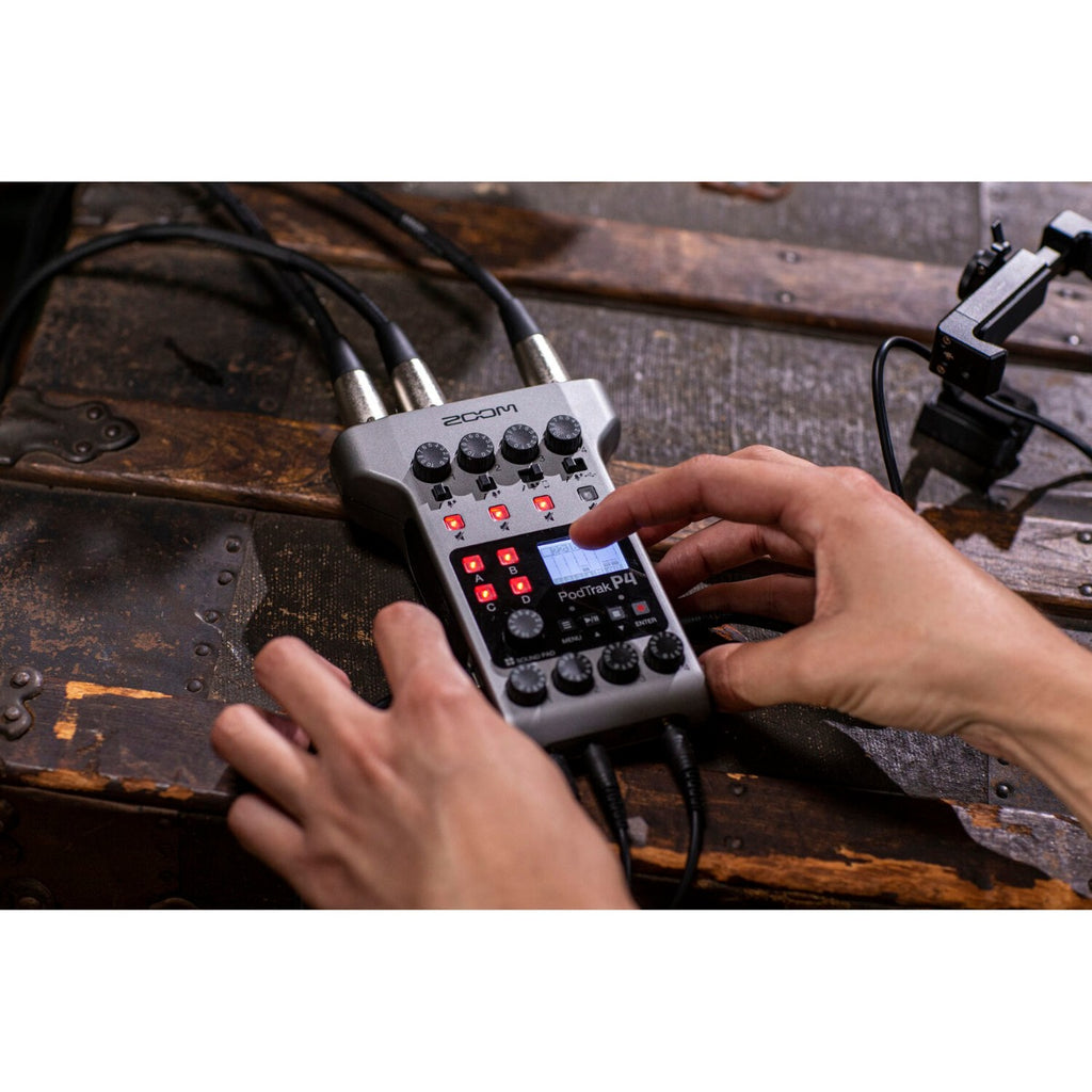 Zoom PodTrak P4 digital recorder with microphone inputs and control knobs, compact portable design for podcast recording