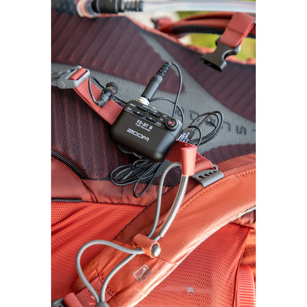 Zoom F2-BT digital recorder with built-in microphones and control buttons, compact and portable for high-quality audio recording.