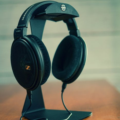 K&M 16075 headphone stand with sleek black design, holding headphones securely on a desk or workspace.