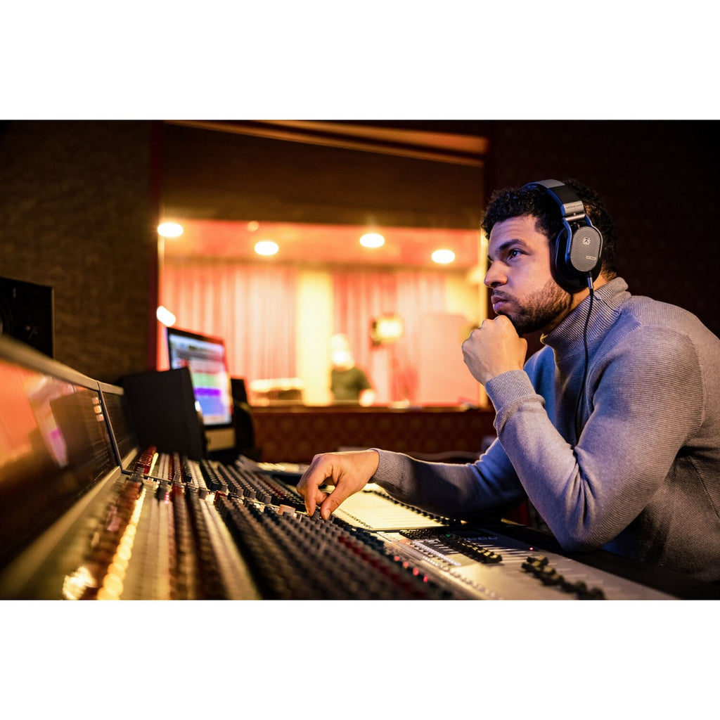 Austrian Audio Hi-X65 studio headphones with over-ear design and black ear cups, shown resting on a table.
