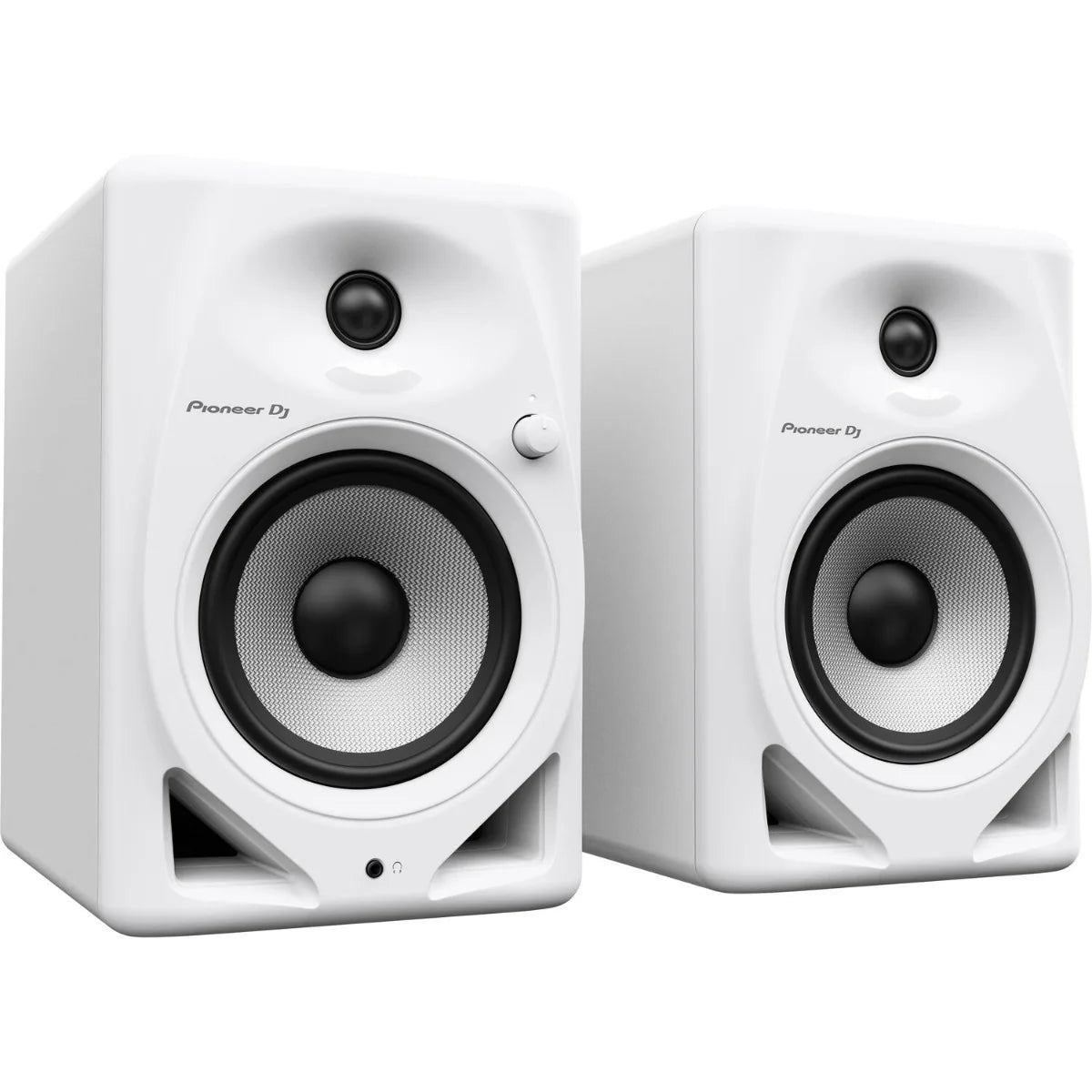 Pioneer DJ DM-50D desktop speakers shown on a desk with audio equipment in the background.