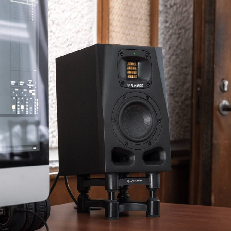 Adam Audio A4V studio monitors with sleek design and front-firing bass port, ideal for professional audio workspaces.