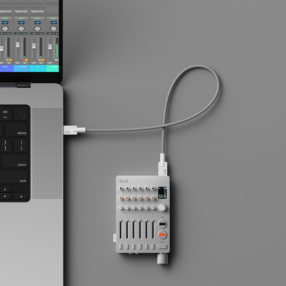 Teenage Engineering TX–6 portable mixer with multiple input channels, colorful control knobs, and compact design.