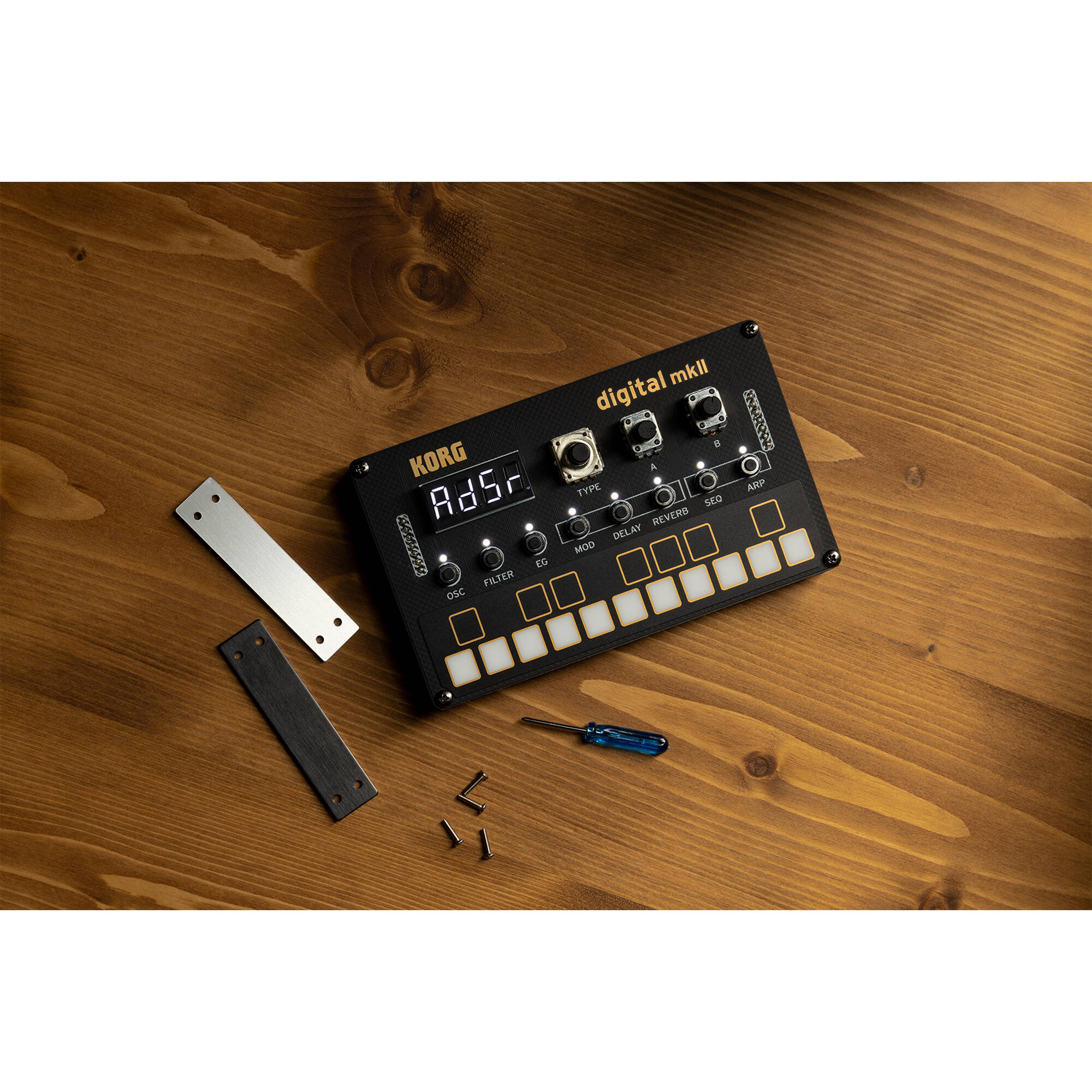 Korg Nu:Tekt NTS-1 MK2 digital synthesizer kit, showing the compact synthesizer with control knobs and a small display screen.