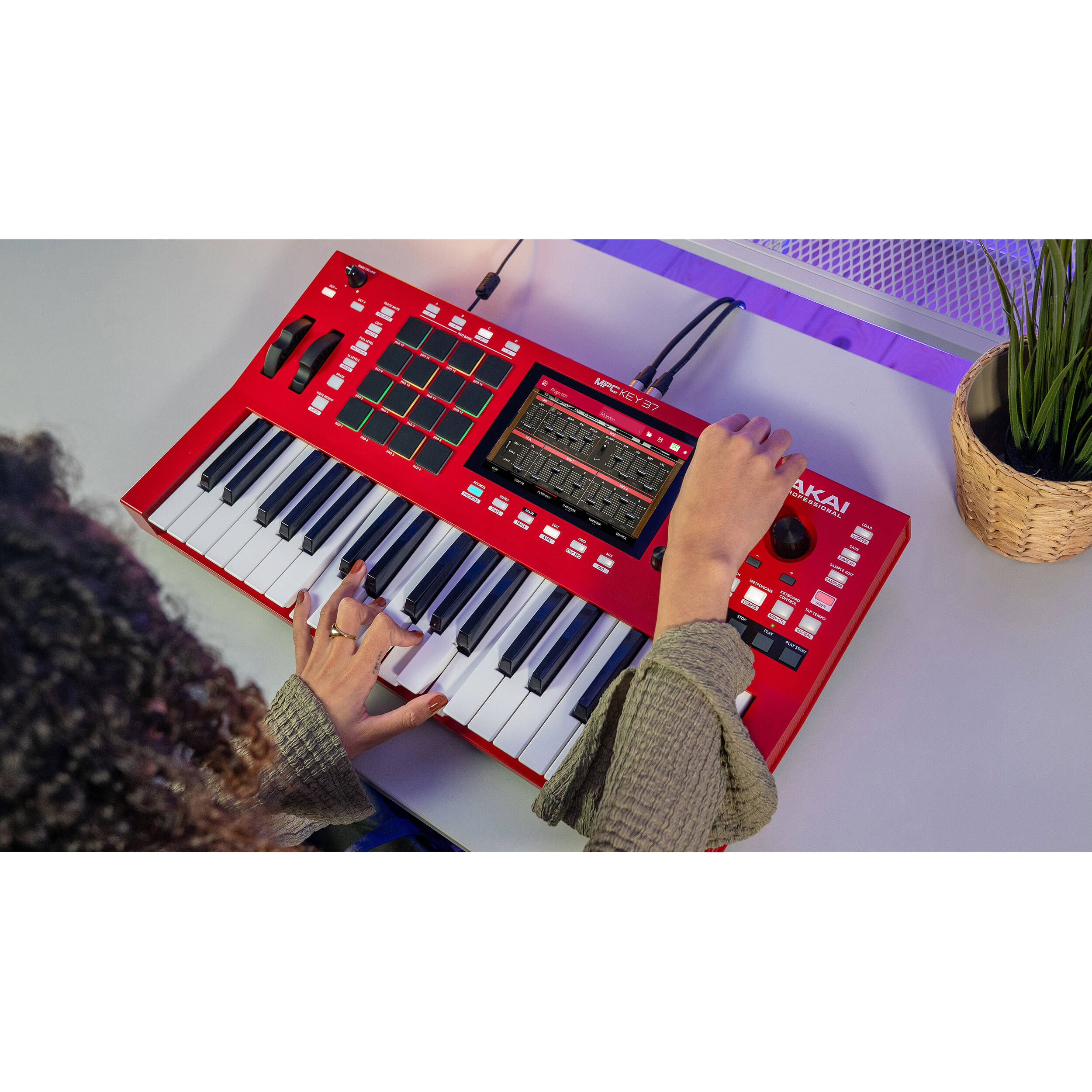 Akai Professional MPC Key 37 MIDI controller with red casing, featuring keyboard keys and control knobs for music production.