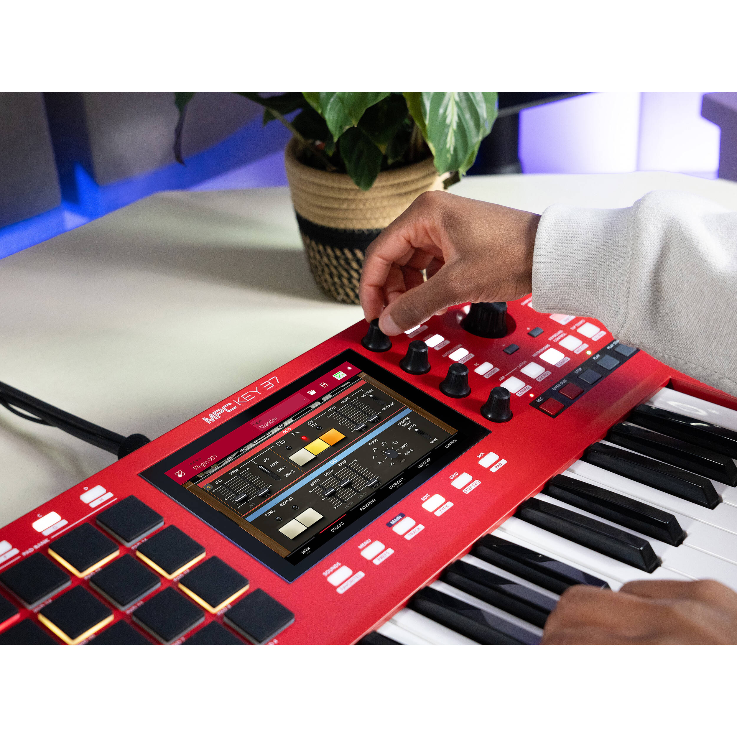Akai Professional MPC Key 37 MIDI controller with red casing, featuring keys, knobs, and pads for music production and sampling.