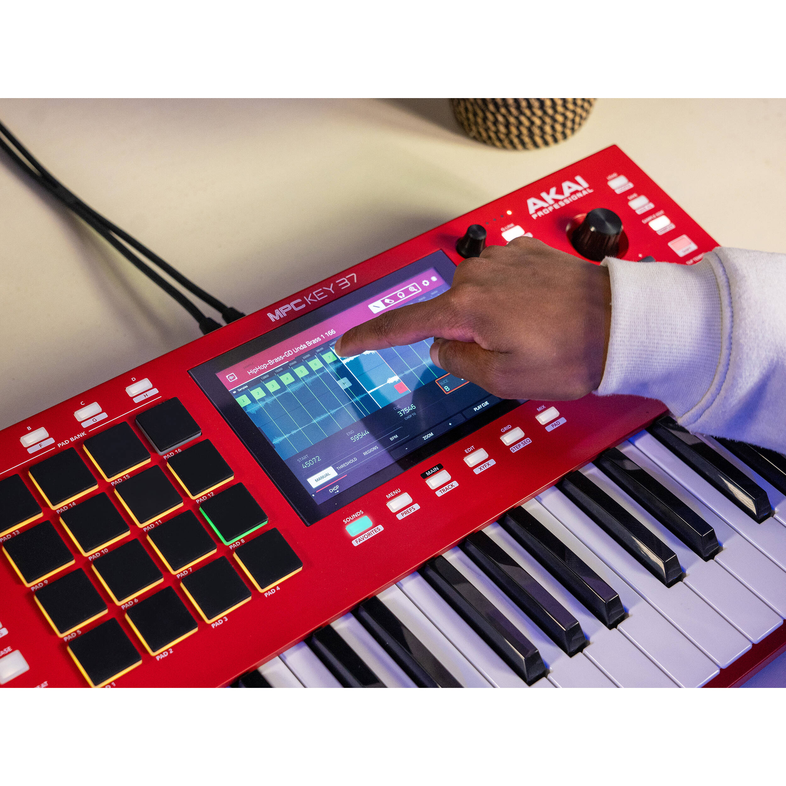 Red Akai Professional MPC Key 37 drum machine and sampler with keys, knobs, and control buttons for music production.