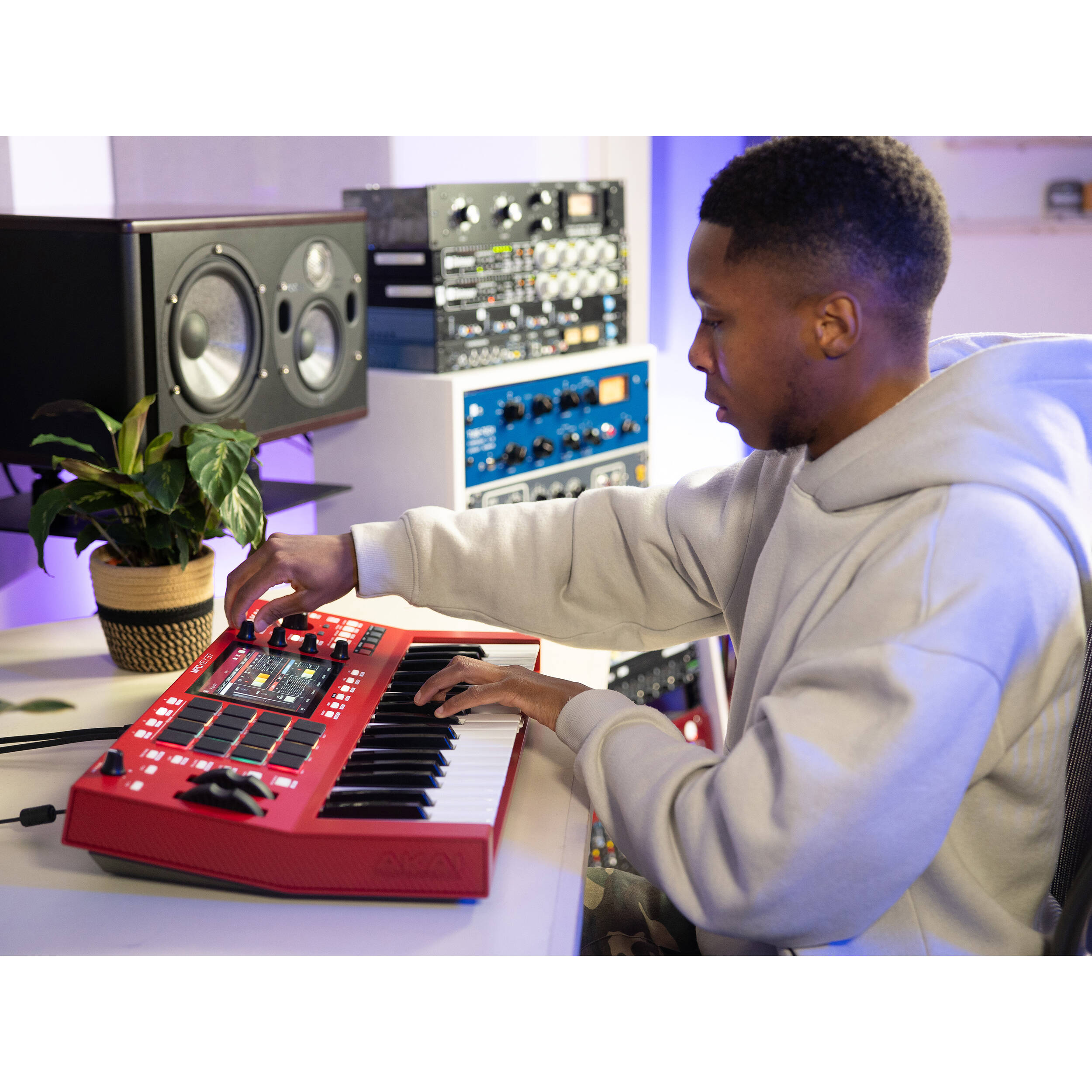 Akai Professional MPC Key 37 MIDI controller with red design, featuring keys, pads, and controls for music production.