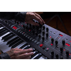 Sequential Trigon-6 synthesizer with a sleek black panel, multiple knobs and buttons, and a compact design for music production.