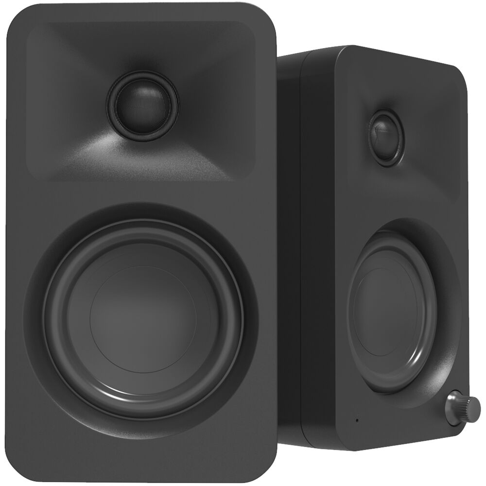 Kanto Audio Ora desktop speakers shown on a desk with a sleek black design and modern aesthetic.