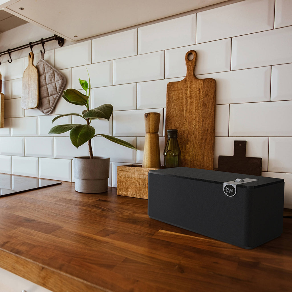 Wireless speaker Klipsch The Three Plus with wooden enclosure and control knobs, designed for premium audio playback.