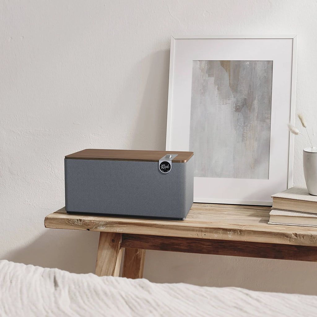 Klipsch The Three Plus wireless speaker with wooden cabinet, featuring a vintage-inspired design and control knobs.