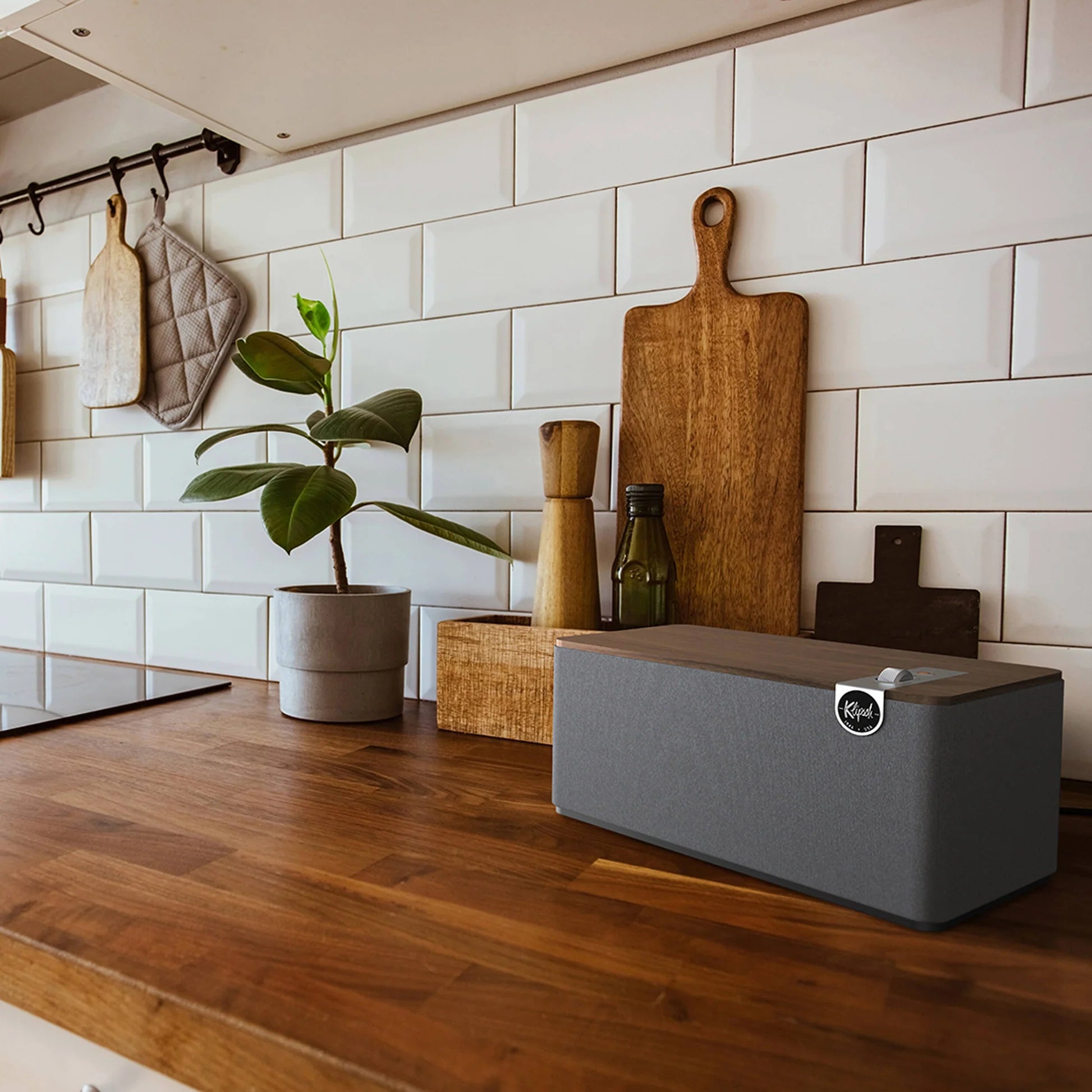 Klipsch The Three Plus wireless speaker with wooden finish and control knobs on top, designed for high-quality audio.