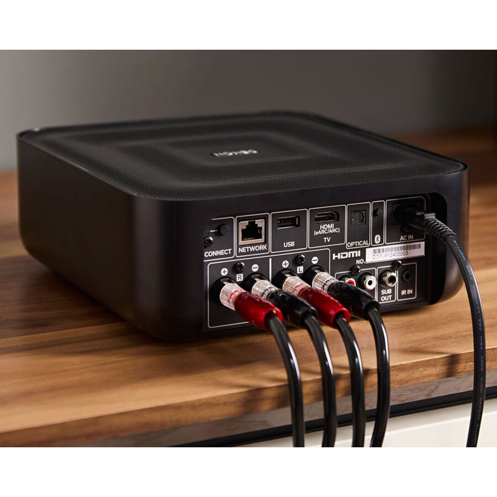 Denon Home Amp stereo amplifier with sleek black design, multiple input ports, and control knobs on the front panel.