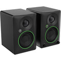 Black Mackie CR3.5 desktop speakers shown on a desk with a clean, modern setup. Compact audio speakers for computer use.