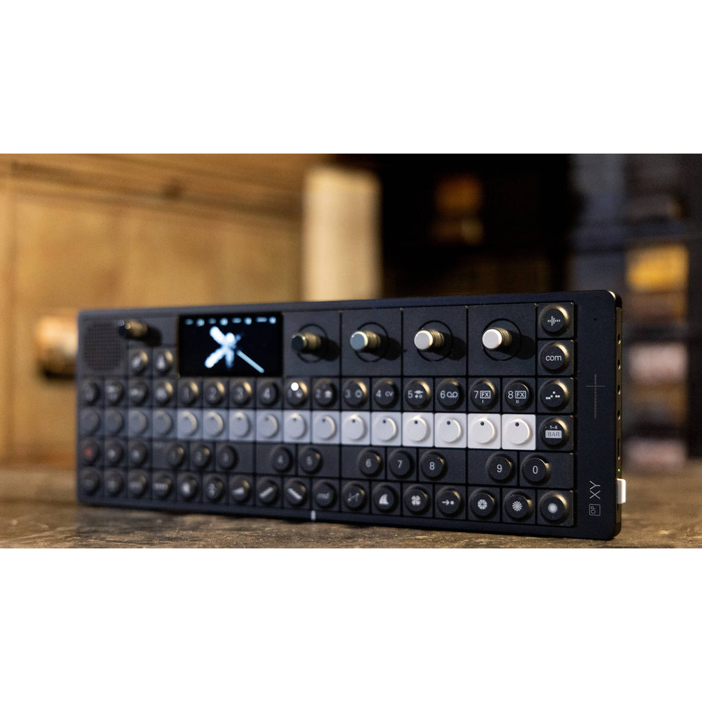 Teenage Engineering OP-XY synthesizer with colorful knobs and controls, showing digital display and compact design.