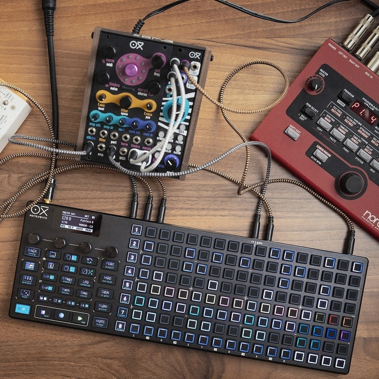 Black OXI Instruments One MKII sequencer with control knobs and LED display, designed for electronic music production.