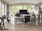 KEF LS50 Meta passive bookshelf speakers in mineral white, shown in a home studio setup with a landscape orientation.