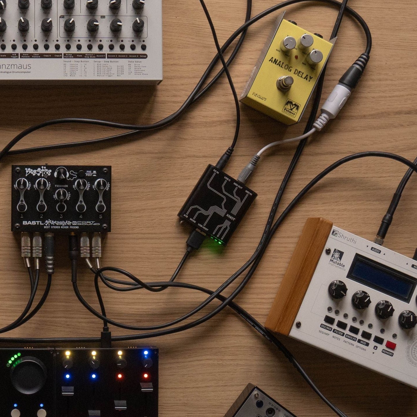 Intech Studio KNOT MIDI interface connected to audio equipment, showcasing its compact design and multiple input/output ports.