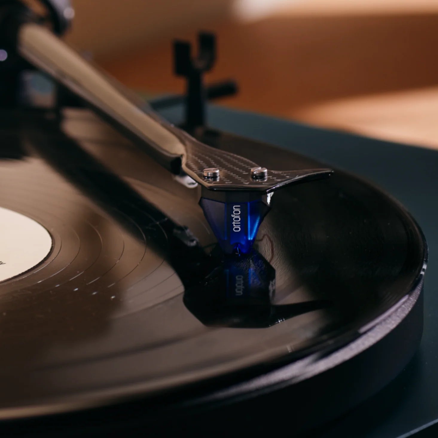 Close-up of the Ortofon 2M Blue cartridge for turntables, showcasing its stylus and sleek blue design.