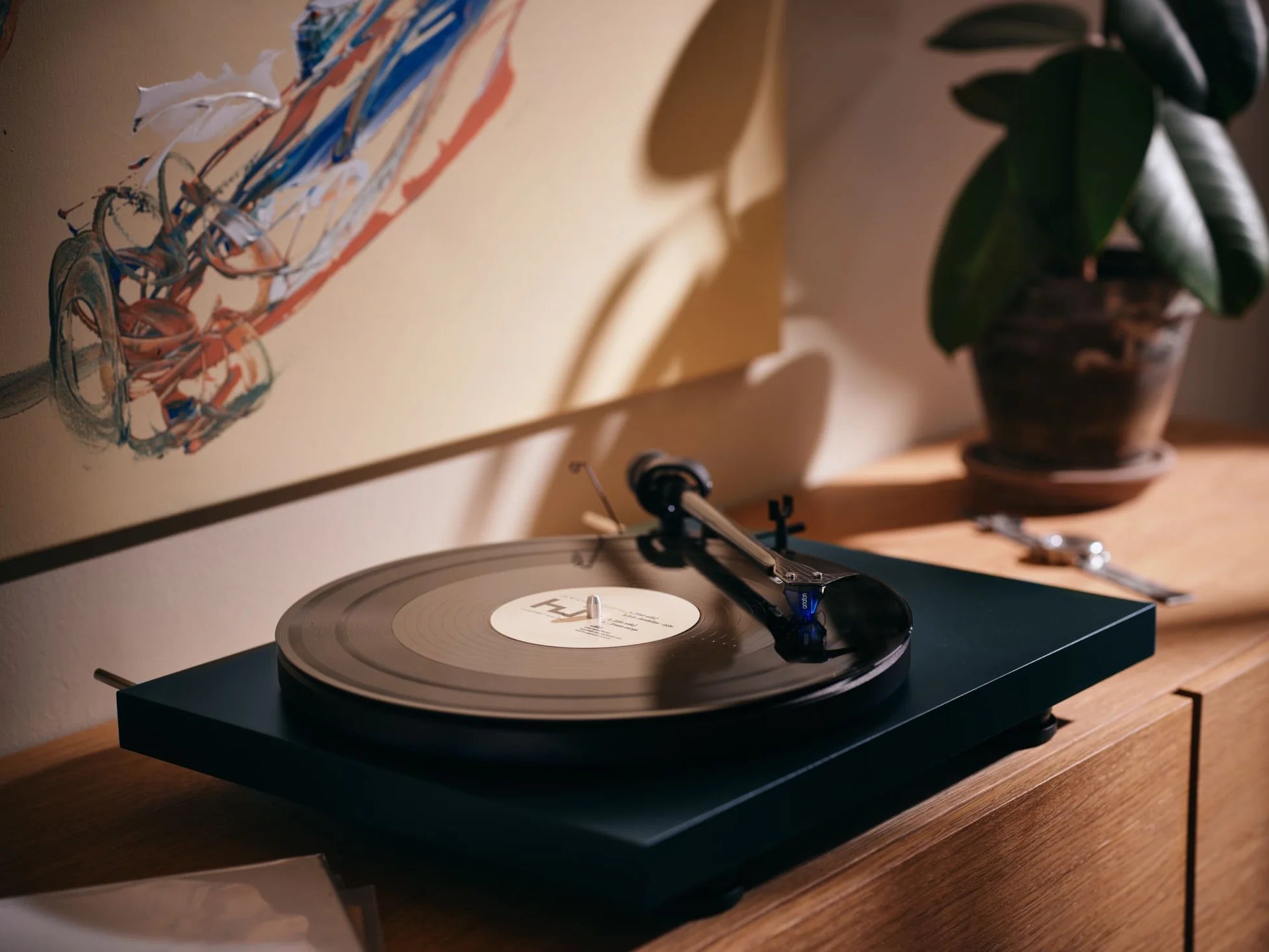 Ortofon 2M Blue turntable stylus cartridge mounted on a turntable, showcasing its sleek design and high-quality audio components.