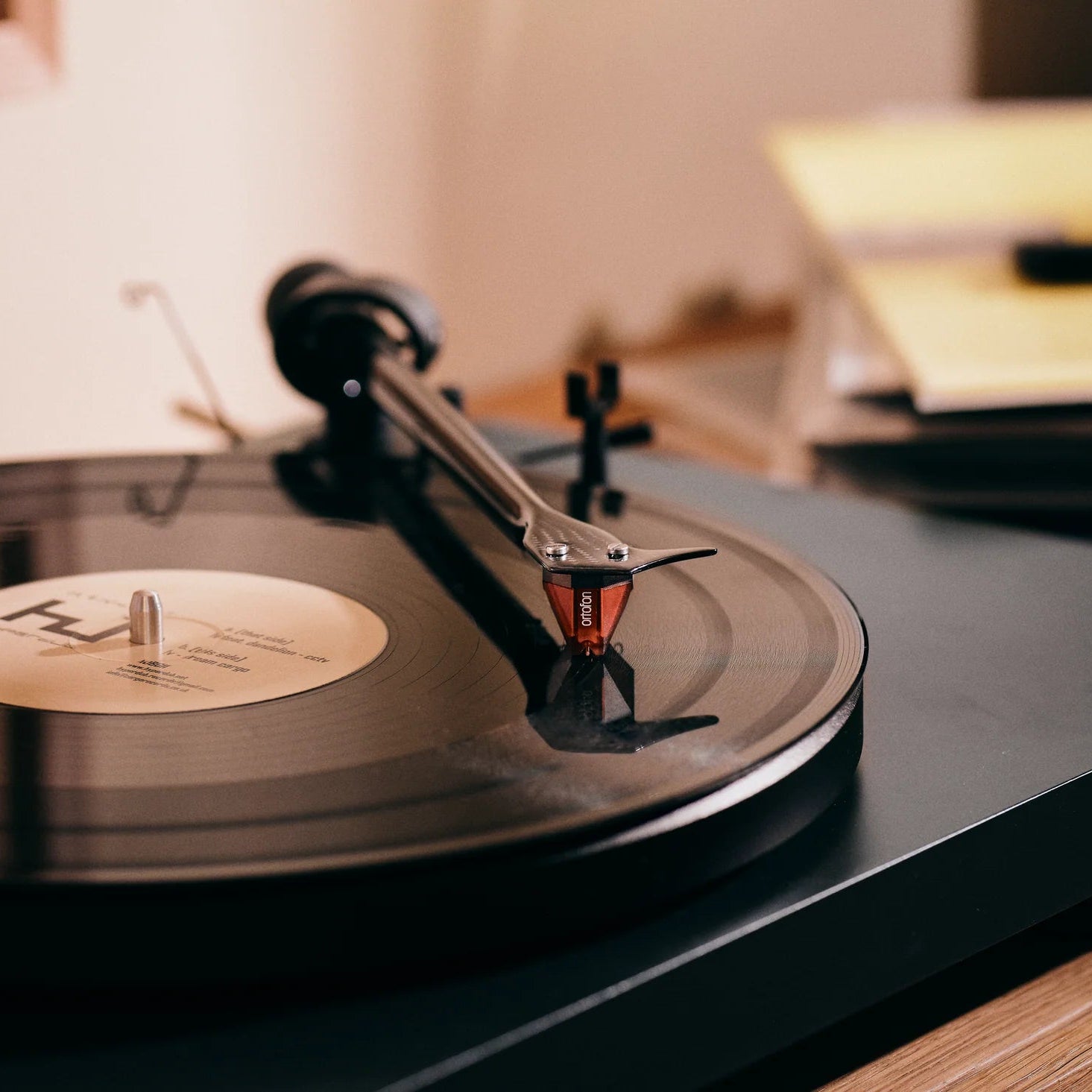 Ortofon 2M Red turntable cartridge mounted on a tonearm, showcasing its sleek design for high-quality vinyl playback.