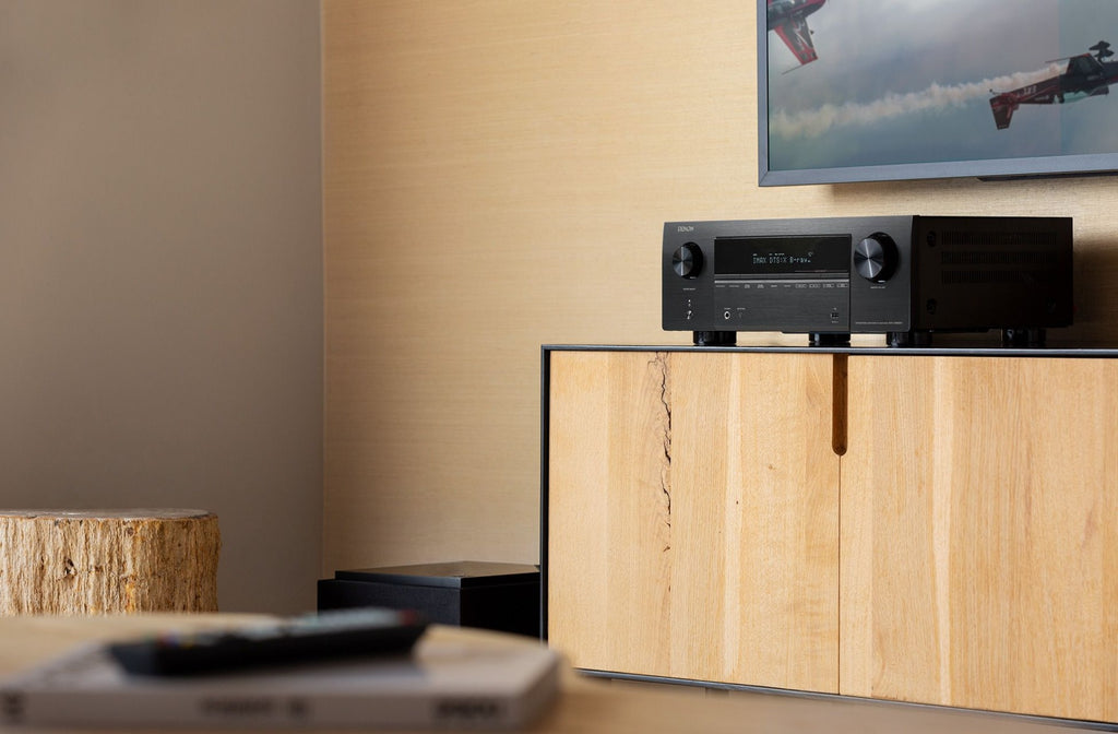 Denon AVC-X3800H stereo amplifier with multiple input ports and sleek black design, showcasing front panel controls and display.