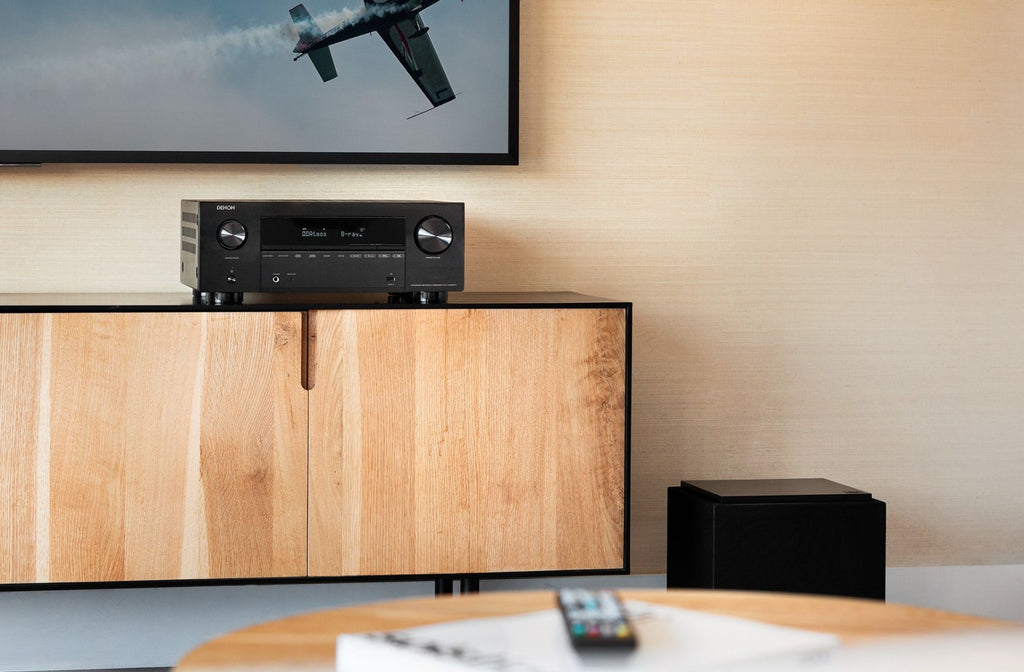 Denon AVC-X3800H stereo amplifier with front control panel, set on a white background, showcasing its sleek design.