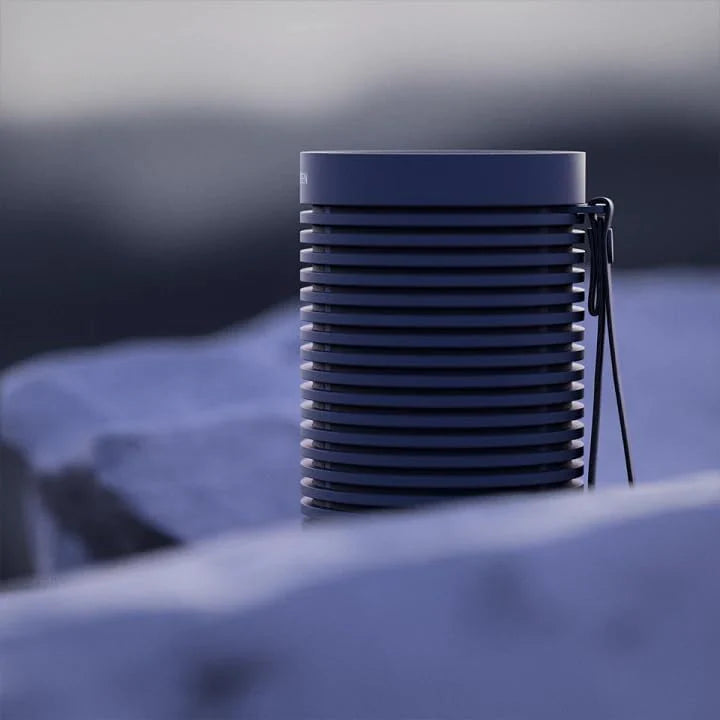 Bang & Olufsen Beosound Explore portable speaker in black, showing its rugged design and compact size for outdoor listening.