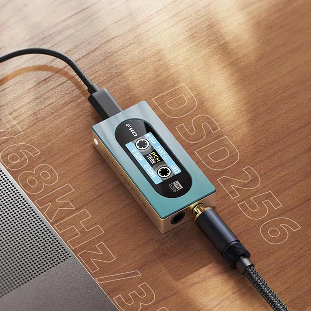 FiiO KA15 headphone amplifier and DAC with sleek black design, multiple input ports, and control knobs for high-quality audio.