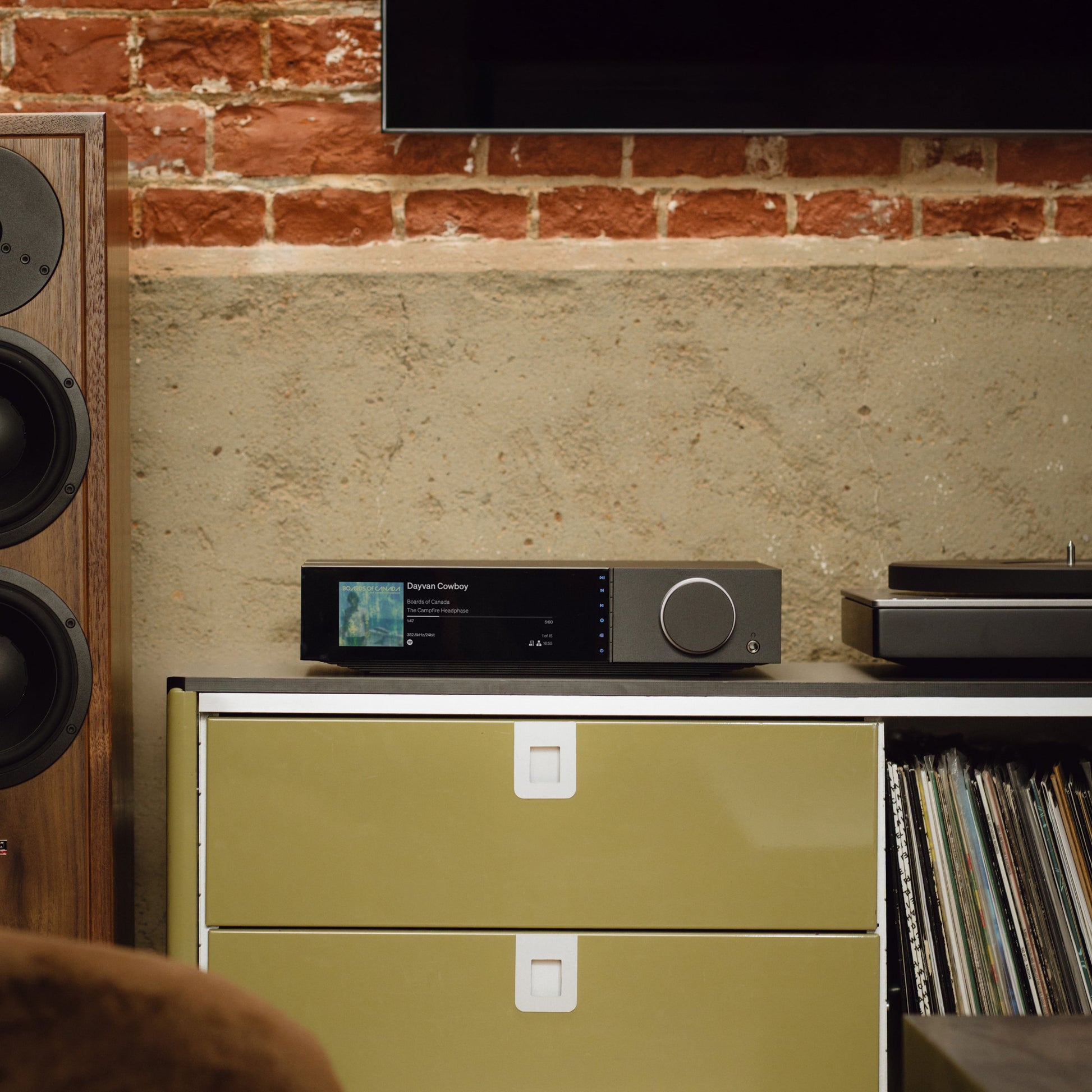 Cambridge Audio Evo 300 streaming amplifier on a media console with a floorstanding speaker and vinyl records