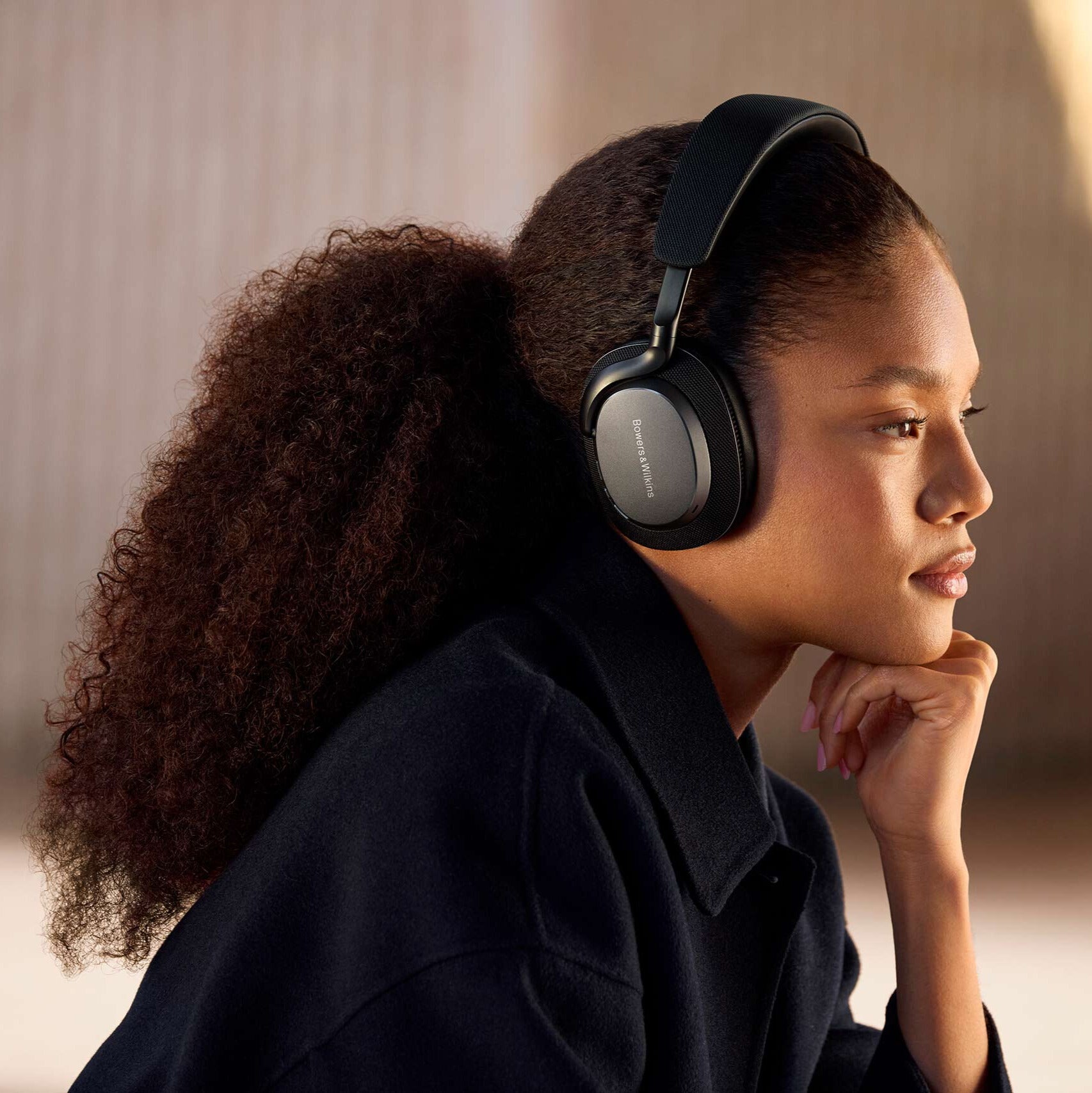 Bowers & Wilkins Px7 S3 wireless headphones with cushioned ear cups and sleek black design, resting on a surface.