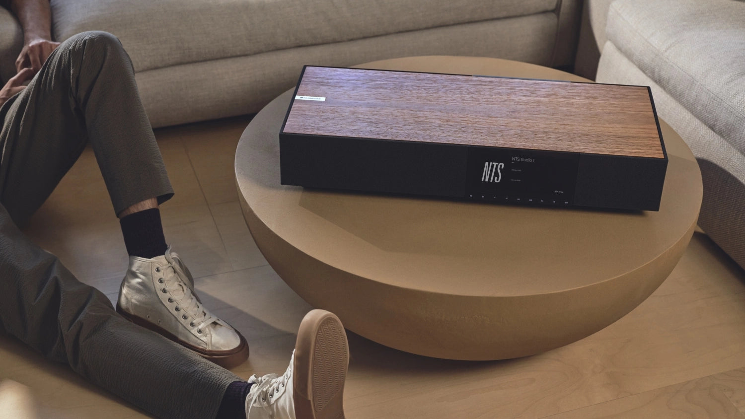 Cambridge Audio Evo One wireless speaker shown from full width, featuring sleek design and control buttons on top.
