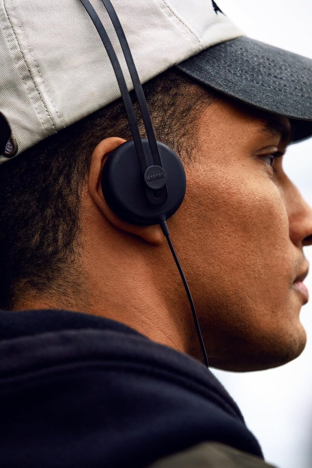 AIAIAI wired headphones with over-ear design, black color, and adjustable headband, shown in a close-up view.