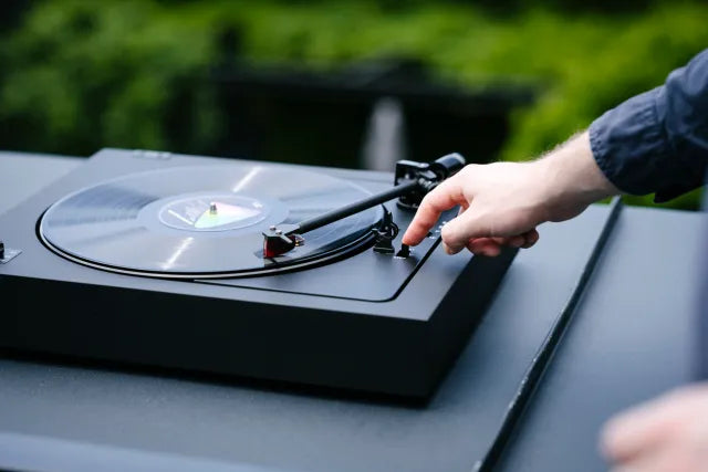 Pro-Ject Automat A2 turntable with 2M Red cartridge in a modern living room setting, showcasing its sleek design and tonearm.
