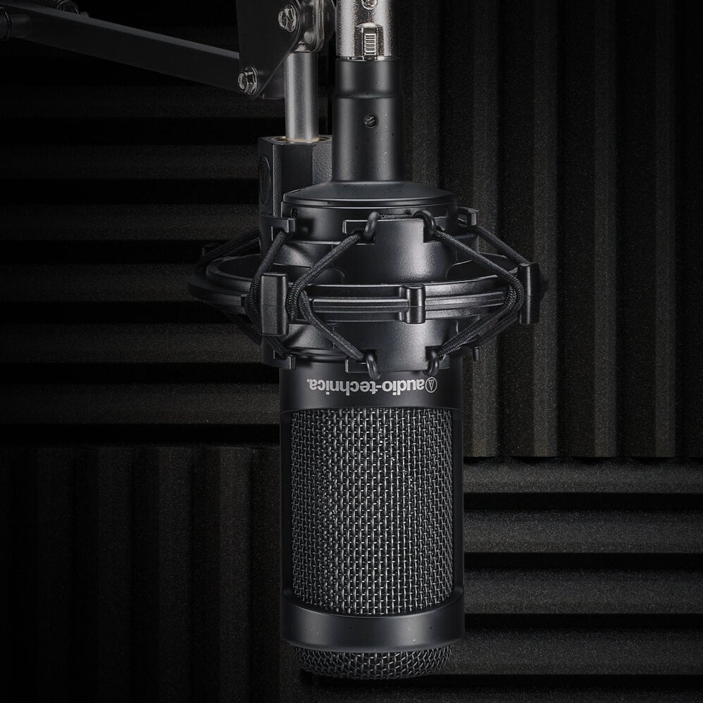Audio Technica AT 2035 condenser microphone on a stand, ready for professional recording in a studio setting.