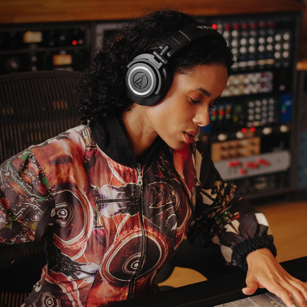 Audio Technica ATH-M50x studio headphones in a lifestyle setting, featuring over-ear design and professional audio quality.