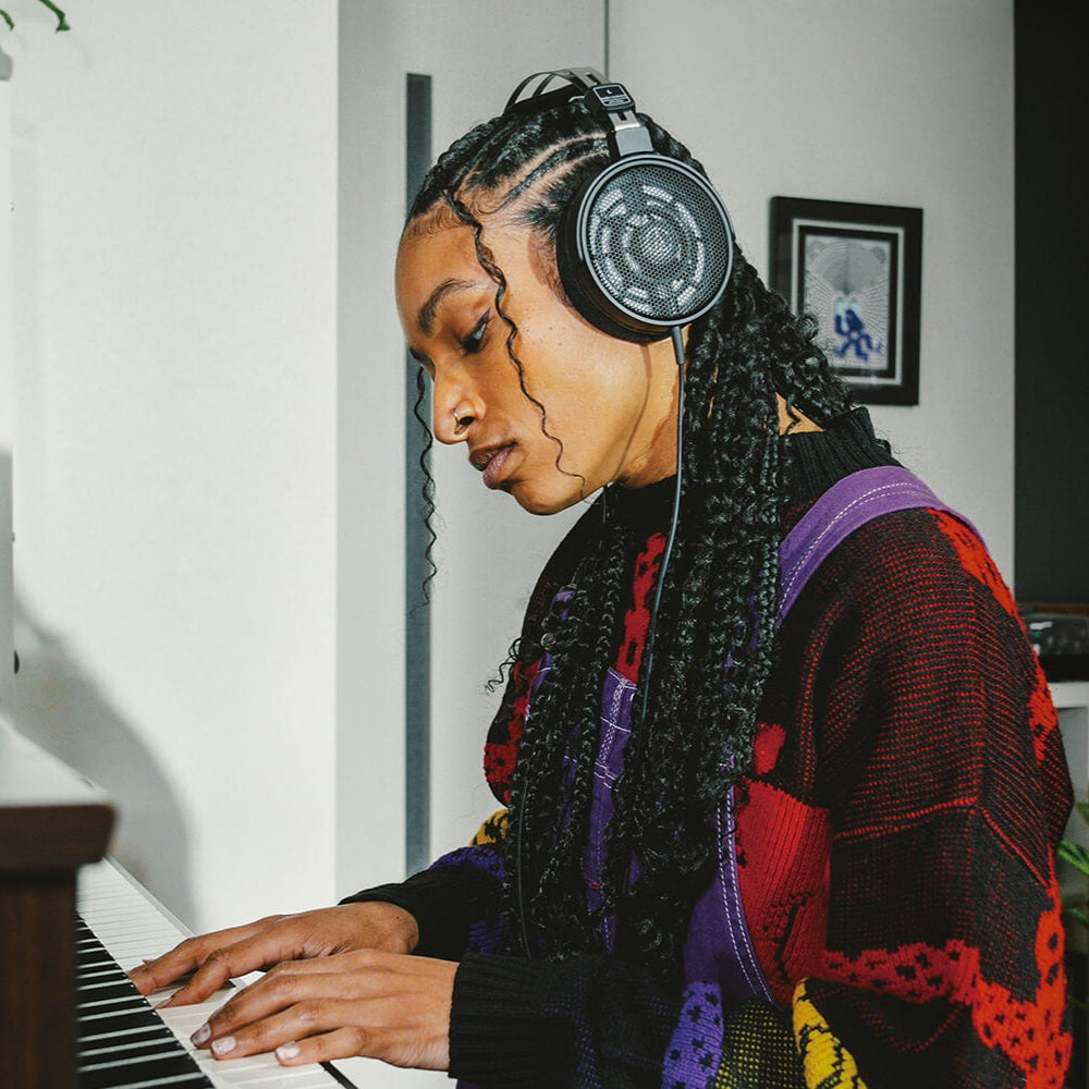 Audio Technica ATH-R30x studio headphones displayed in a lifestyle setting on a desktop banner.