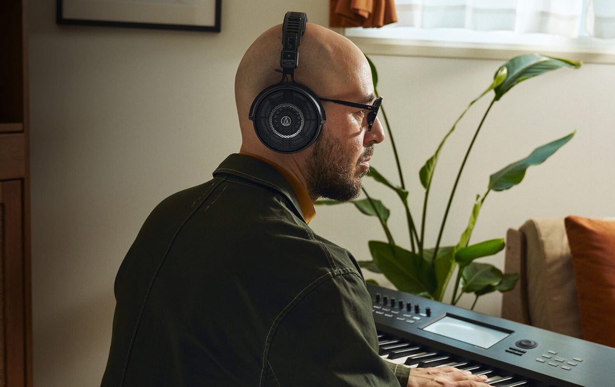 Audio Technica ATH-R50x studio headphones displayed in a lifestyle setting, featuring over-ear design and black finish for professional listening.