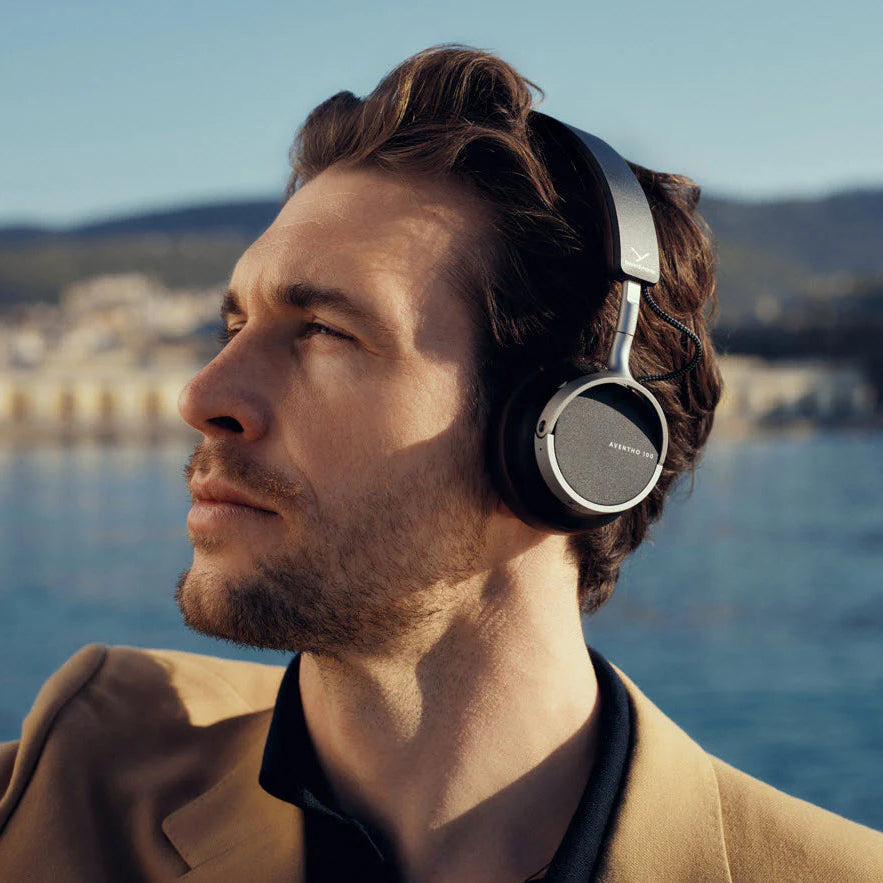 Beyerdynamic Aventho 100 wireless headphones in black shown in a lifestyle setting with sleek design and over-ear fit.