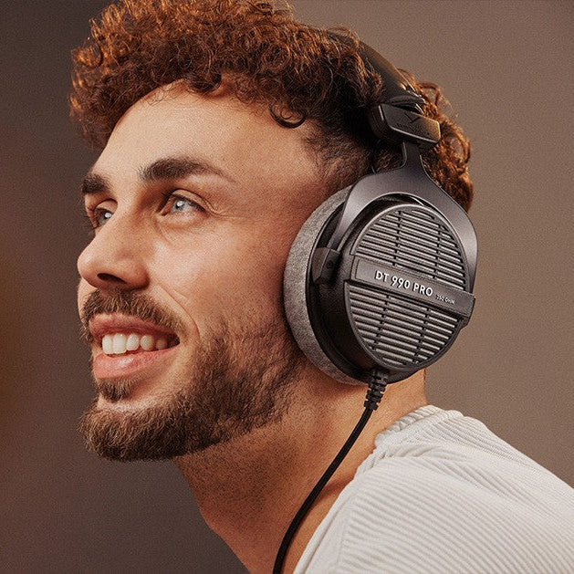 Beyerdynamic DT 990 Pro studio headphones with open-back design, black ear cups, and adjustable headband for mixing and mastering.