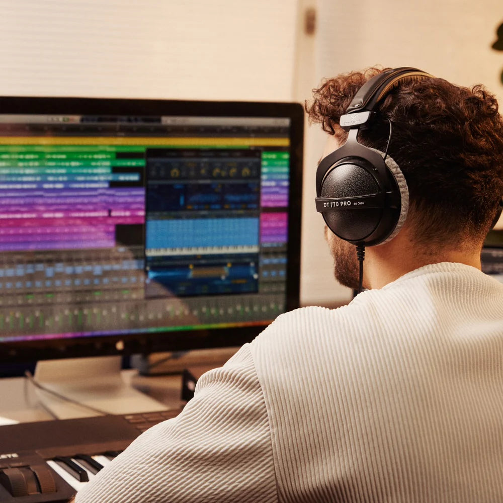 Beyerdynamic DT 770 Pro studio headphones with 80 ohm impedance, black over-ear design, shown in a music production setting