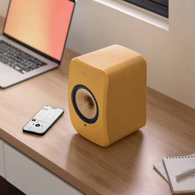 KEF LSX II active bookshelf speakers in Amber Haze and Cotton White finish, showcasing sleek modern design.
