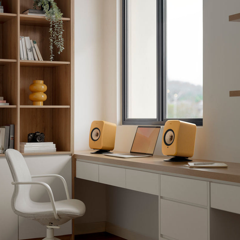 KEF LSX II active bookshelf speakers in Amber Haze and Cotton White finish, showcasing sleek modern design and compact form.