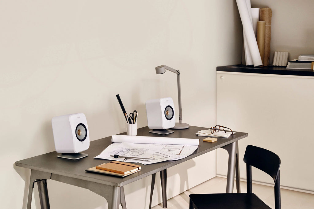 KEF P1 desk pad used as speaker stand, with sleek design and cushioning for optimal speaker placement on a desk surface.